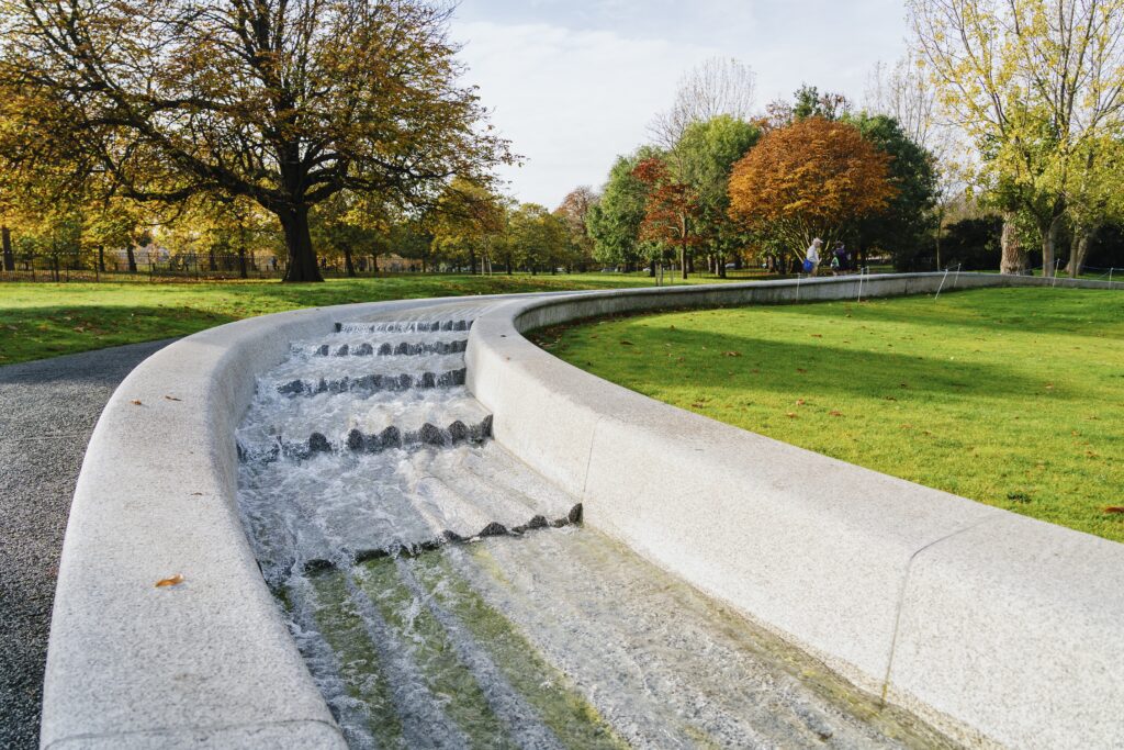 Princess Diana Memorial Fountain surrounded by greenery under the sunlight in London, England
