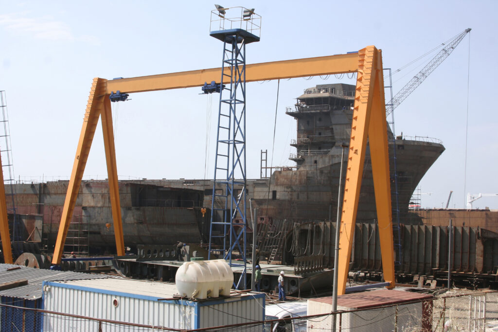 Shipbuilding pier and crane. Workers working on the pier.